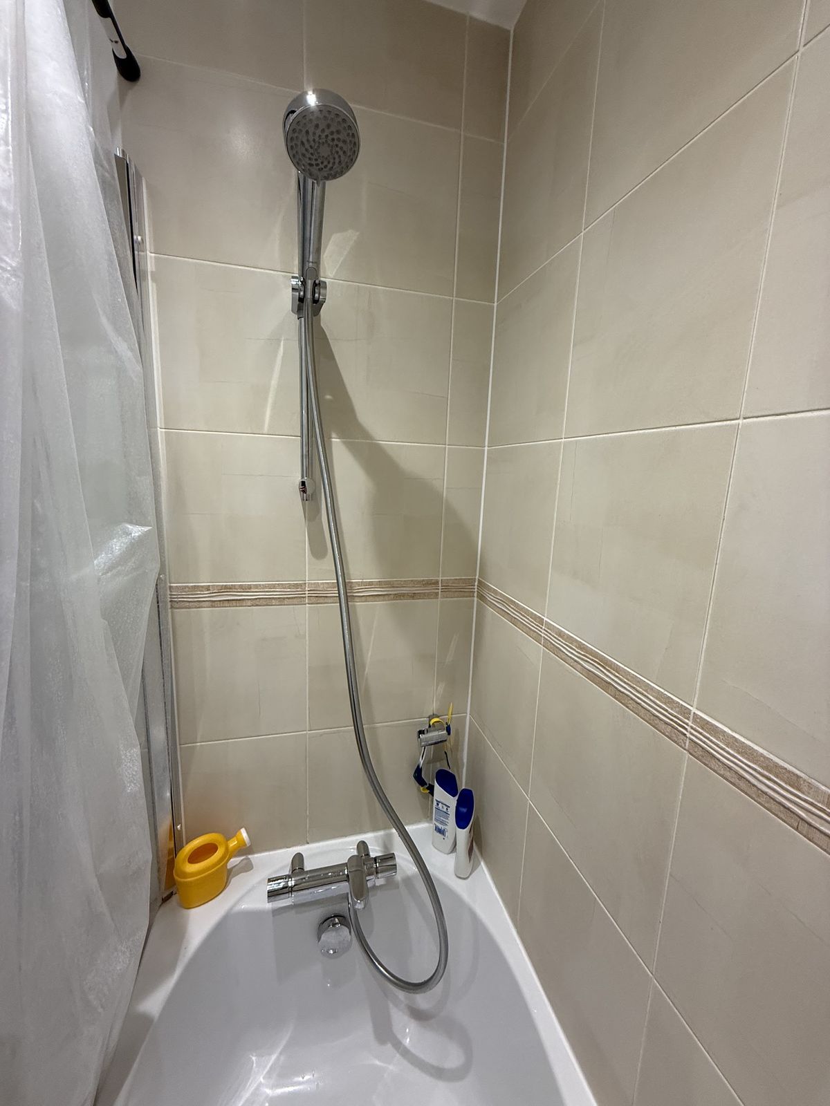 A thermostatic bath shower fitted on a tiled wall